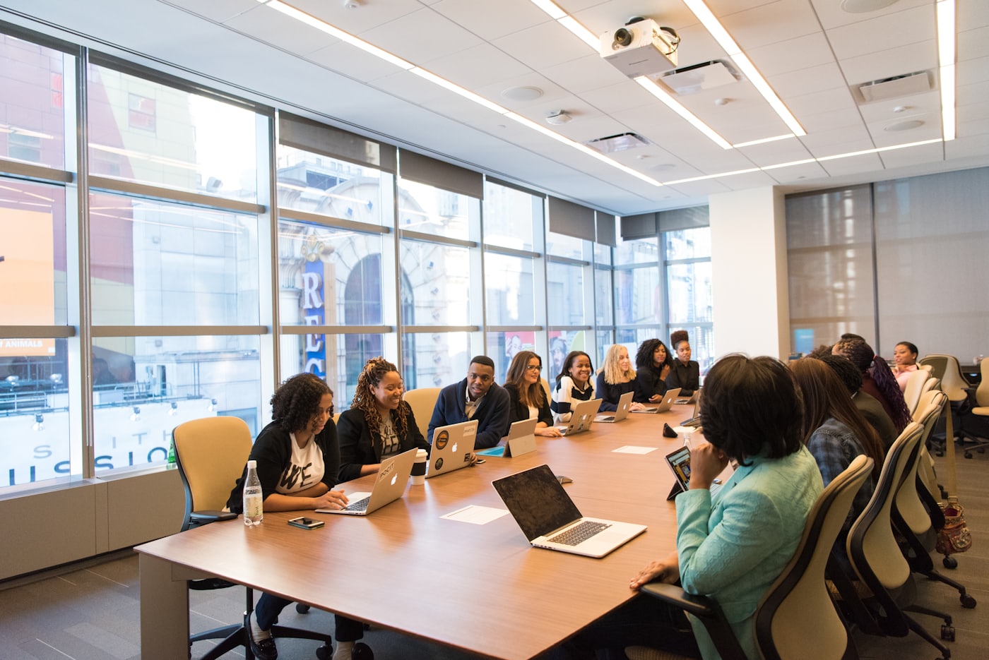 Diverse team of professionals collaborating around laptops in a conference room