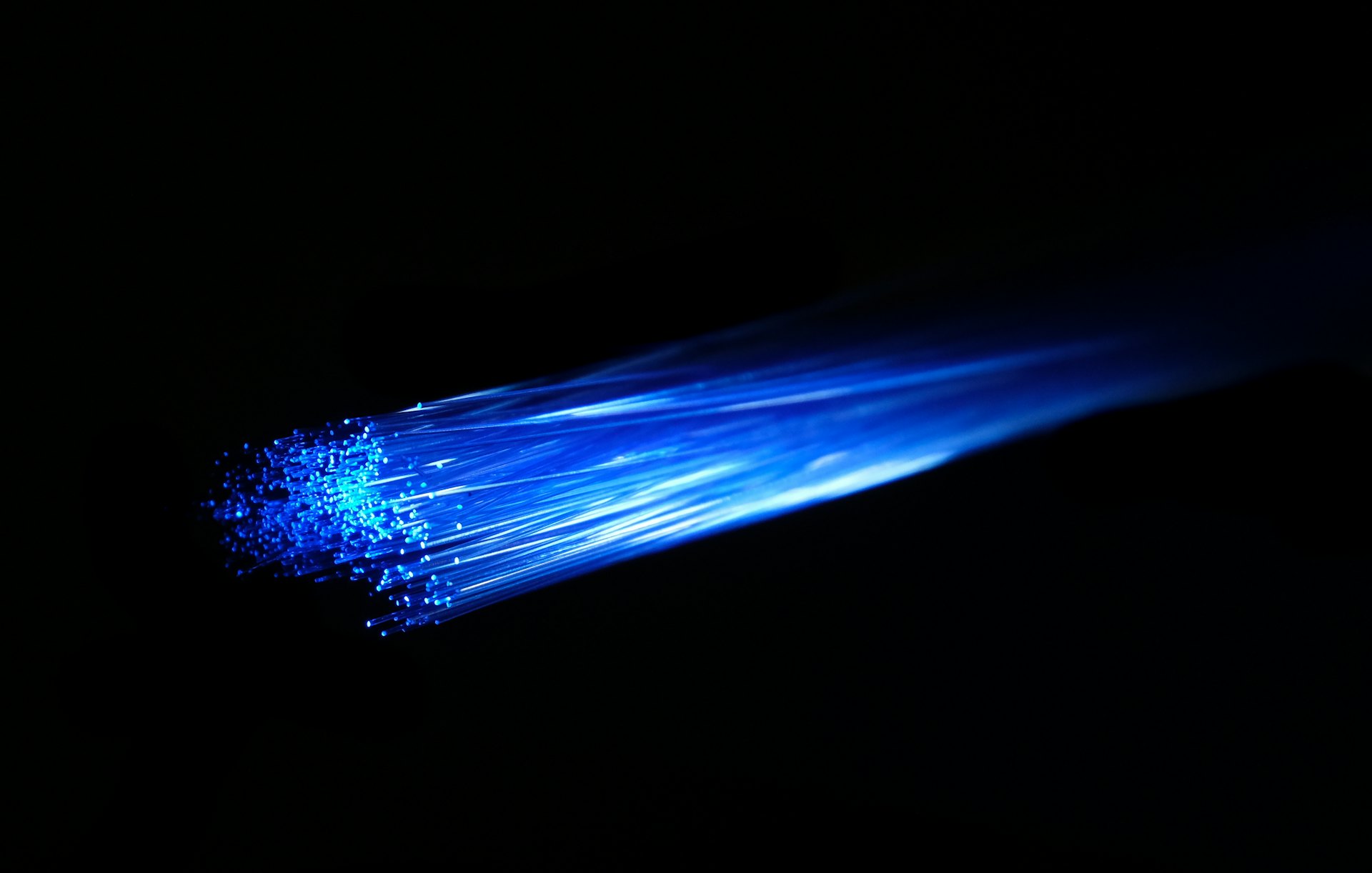 Glowing blue fibre-optic strands against a dark background