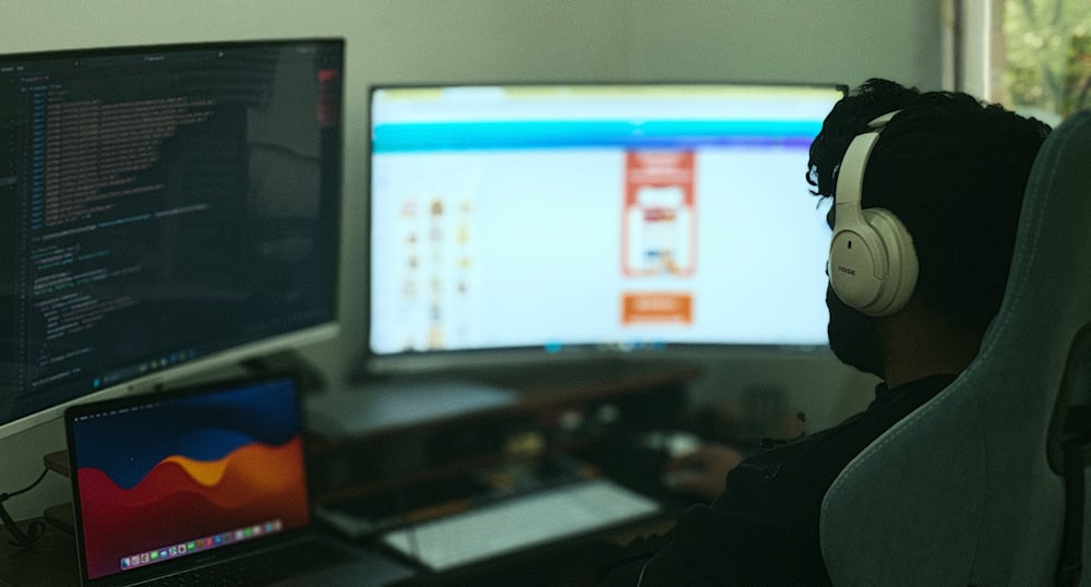IT professional working across multiple monitors